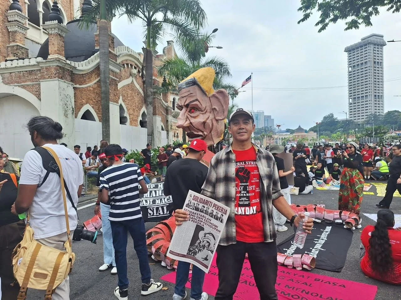 Pekerja bersama akhbar Solidariti Pekerja edisi ke-34 dengan tajuk muka hadapan 'Ketidakstabilan Perang dan Ekonomi Mengancam Kehidupan Kelas Pekerja'.