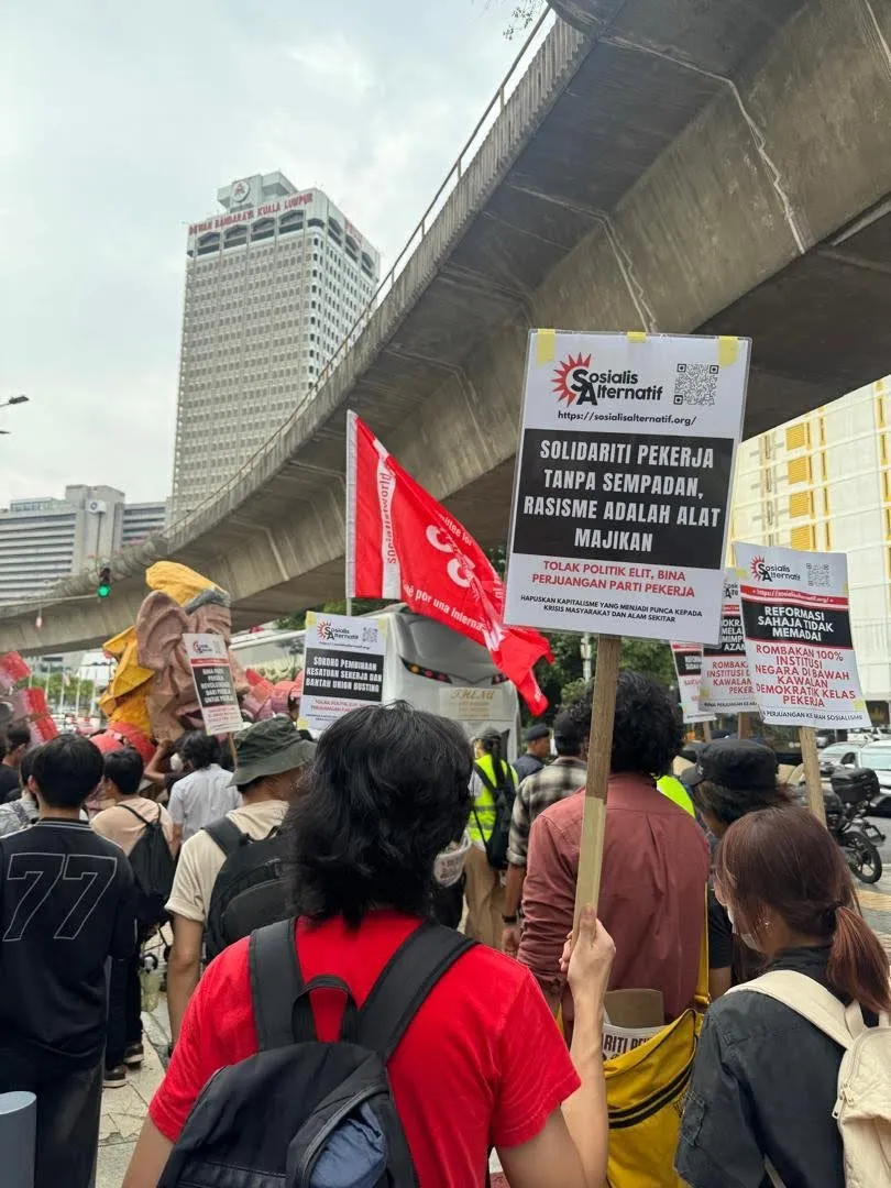 Kontinjen Sosialis Alternatif membawa plakad ‘Solidariti Pekerja Tanpa Sempadan, Rasisme Adalah Alat Majikan’.