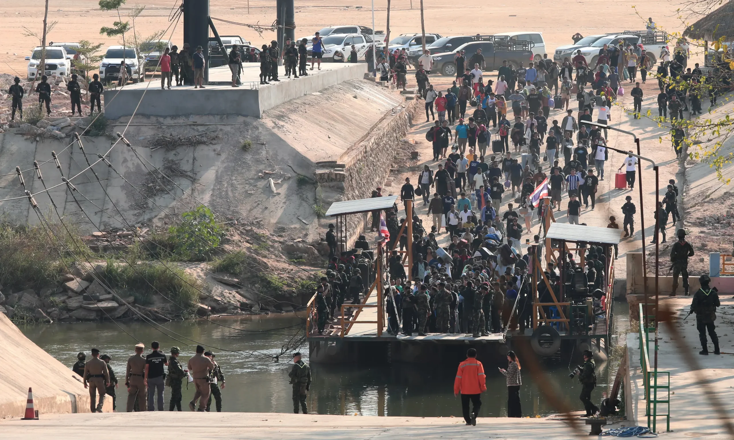 February 12, 2025: “Scammers” rescued from scam compounds in Myanmar are brought aboard a barge before crossing the border to Thailand. (Source: The Guardian)